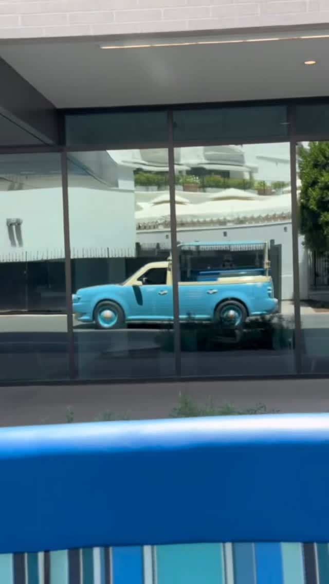 The blue Capri Car reflected in glass