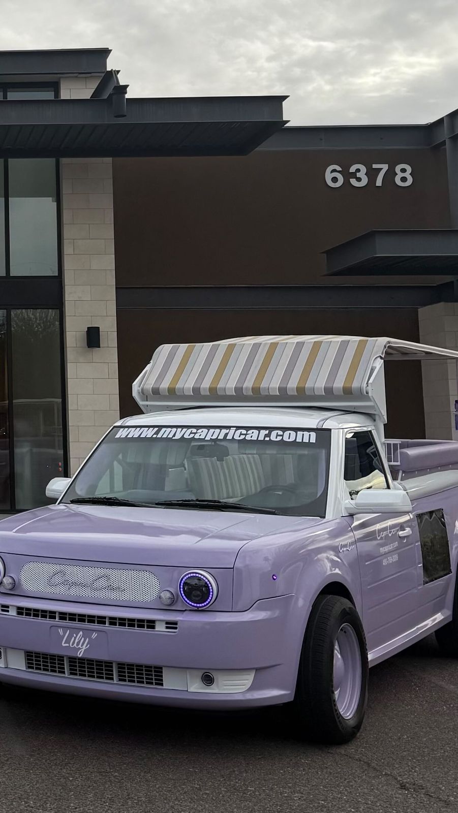 Lily, the lavender Capri Car, parked in front of a Paradise Valley estate